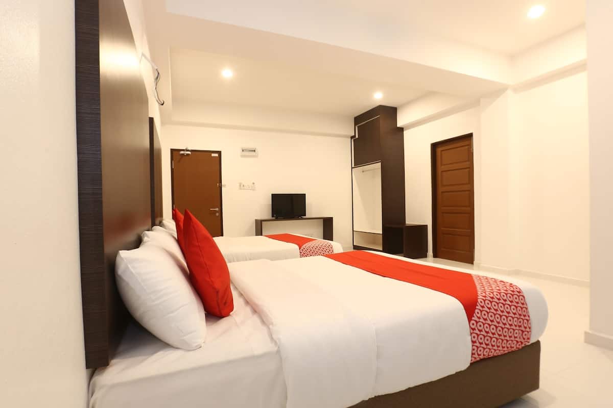 A modern hotel room with a large bed, two bedside tables, a flat-screen TV, and a wardrobe.
