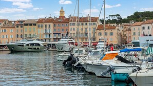 A marina with boats docked, a clock tower, and colorful buildings in the background. - Beachside Bliss in Gassin (Gassin)