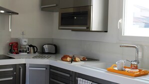 A modern kitchen with stainless steel appliances, a toaster, and a bread rack. - Villa in Languedoc With Pool Near Historic Cities (Rousson)