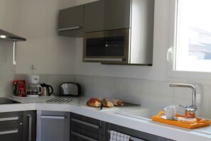 A modern kitchen with stainless steel appliances, a toaster, and a bread rack. - Villa in Languedoc With Pool Near Historic Cities (Rousson)