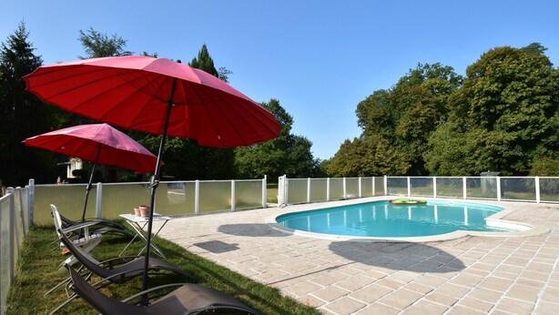 A swimming pool with a white fence, lounge chairs, and red umbrellas. - House in Burgundy With Private Pool (Saint-Aubin-sur-Loire)