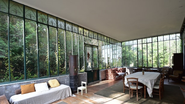 A spacious room with a large window, a sofa, a table with chairs, and a fireplace. - House in Burgundy With Private Pool (Saint-Aubin-sur-Loire)