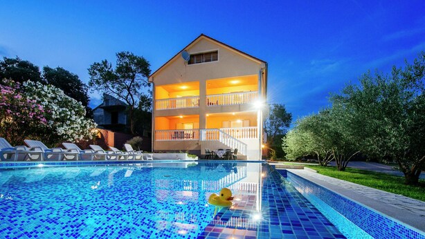 A two-story building with a balcony, a swimming pool with blue tiles, and a yellow duck float. - Spacious Holiday Home With Private Pool (Polaca)