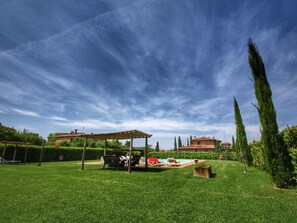 A well-maintained grassy lawn with a pergola, outdoor seating, and a swimming pool. - Cottage in Tuscany With Pool & Olive Groves (Lucignano)