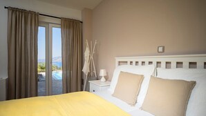 A bedroom with a bed, a nightstand, a lamp, and a view of a pool and landscape.