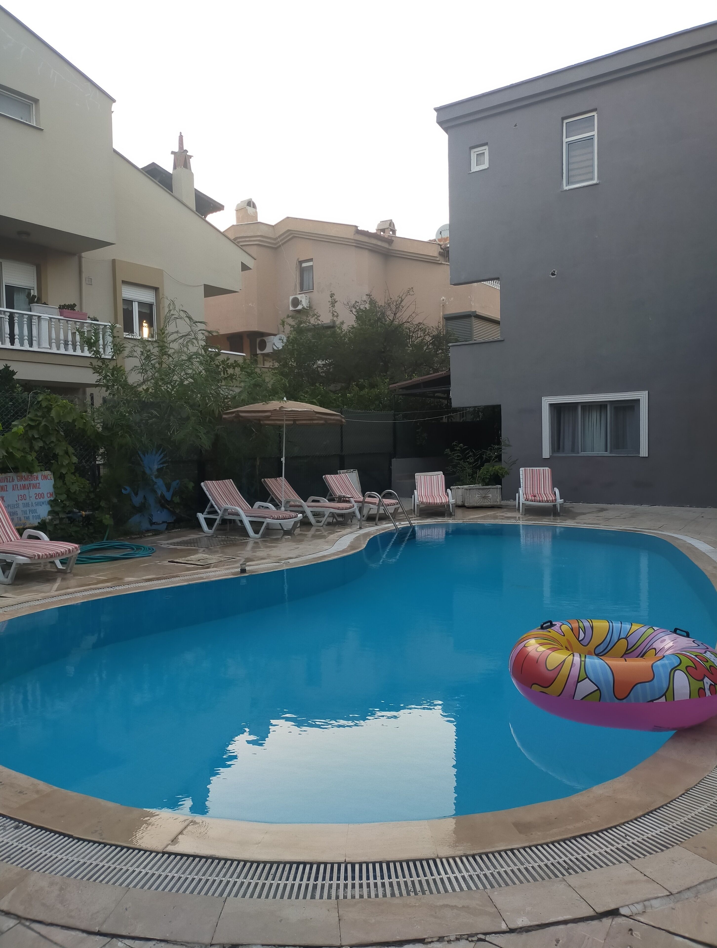 Una piscina al aire libre de temporada, sombrillas, tumbonas