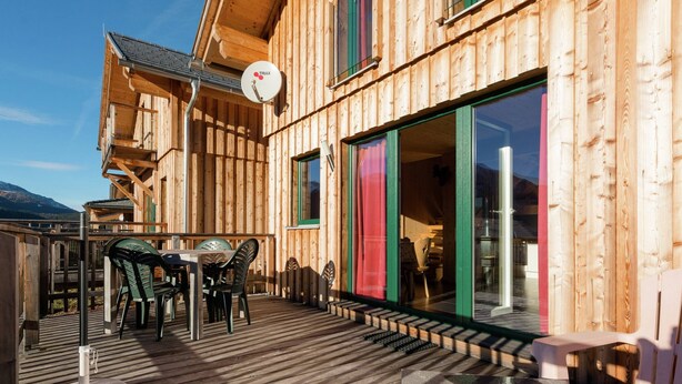 A wooden cabin with a deck, a dining area, and a large sliding glass door. - Chalet in Hohentauern Near Ski Lift (Hohentauern)
