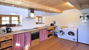 A compact kitchen with wooden cabinets, a built-in oven, a washing machine, and a coffee maker. - Holiday Home in Konzell With Terrace (Konzell)