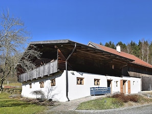 A rustic building with a sloped roof and wooden exterior, featuring a bench and a small garden area in front. - Holiday Home in Konzell With Terrace (Konzell)