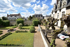 A courtyard with a fountain, neatly trimmed hedges, and a stone wall. - Charming Escape, Yevre-la-ville (Yèvre-la-Ville)
