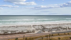 Una playa con una carretera y un puente peatonal que conduce a la orilla.