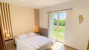 Une chambre à coucher avec un lit, des lampes de chevet, une fenêtre donnant sur un paysage agréable et une tringle à rideaux.