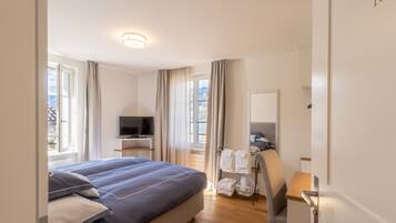 Une chambre d’hôtel avec un lit, une télévision, un bureau et une chaise.
