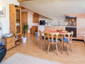Modern kitchen with central island, microwave, coffee maker, and dishwasher. Dining and seating areas complete the space.