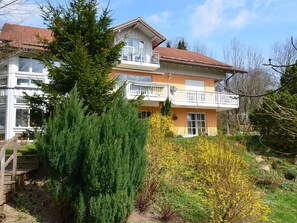 A two-story house with a balcony and a wooden deck.