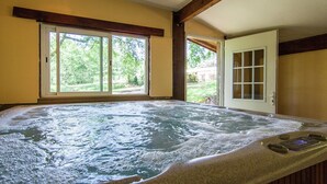 A hot tub with a view of a yard and a door to the right.