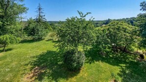 A lush green landscape with trees and a clear blue sky.