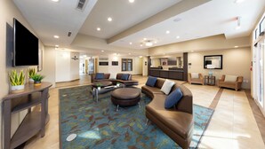 A spacious lobby with a large seating area, a flat-screen TV, and a reception desk. - Candlewood Suites Panama City Beach Pier by IHG (Panama City Beach)