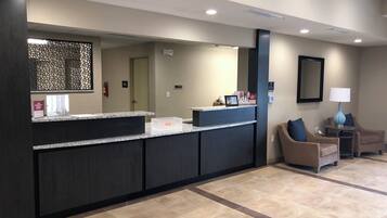 A reception area with a counter, seating, and a mirror.