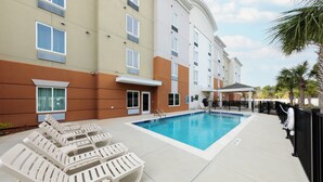 A hotel pool area with lounge chairs and a covered seating area. - Candlewood Suites Panama City Beach Pier by IHG (Panama City Beach)