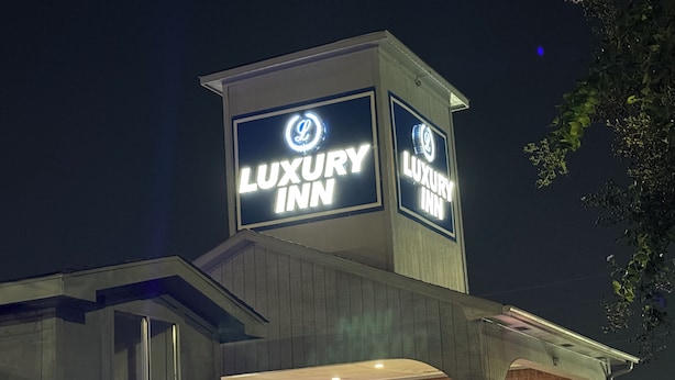 A building with a sign that reads "LUXURY INN". - Luxury Inn and Suites (Houston)