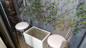 A small, enclosed space with a glass partition, a white table with a glass top, and a chair with a white cushion. - Pet Friendly Apart(9 Person max)+Pool+Grill+Billiards+Gym (Lince)