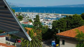 Una marina con numerose imbarcazioni ormeggiate, circondata da edifici e vegetazione.