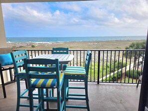 Un balcon avec vue sur la plage et l’océan.