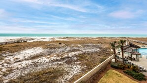 Une propriété située en bord de mer, dotée d’une piscine, d’une terrasse en bois et offrant une vue sur l’océan.