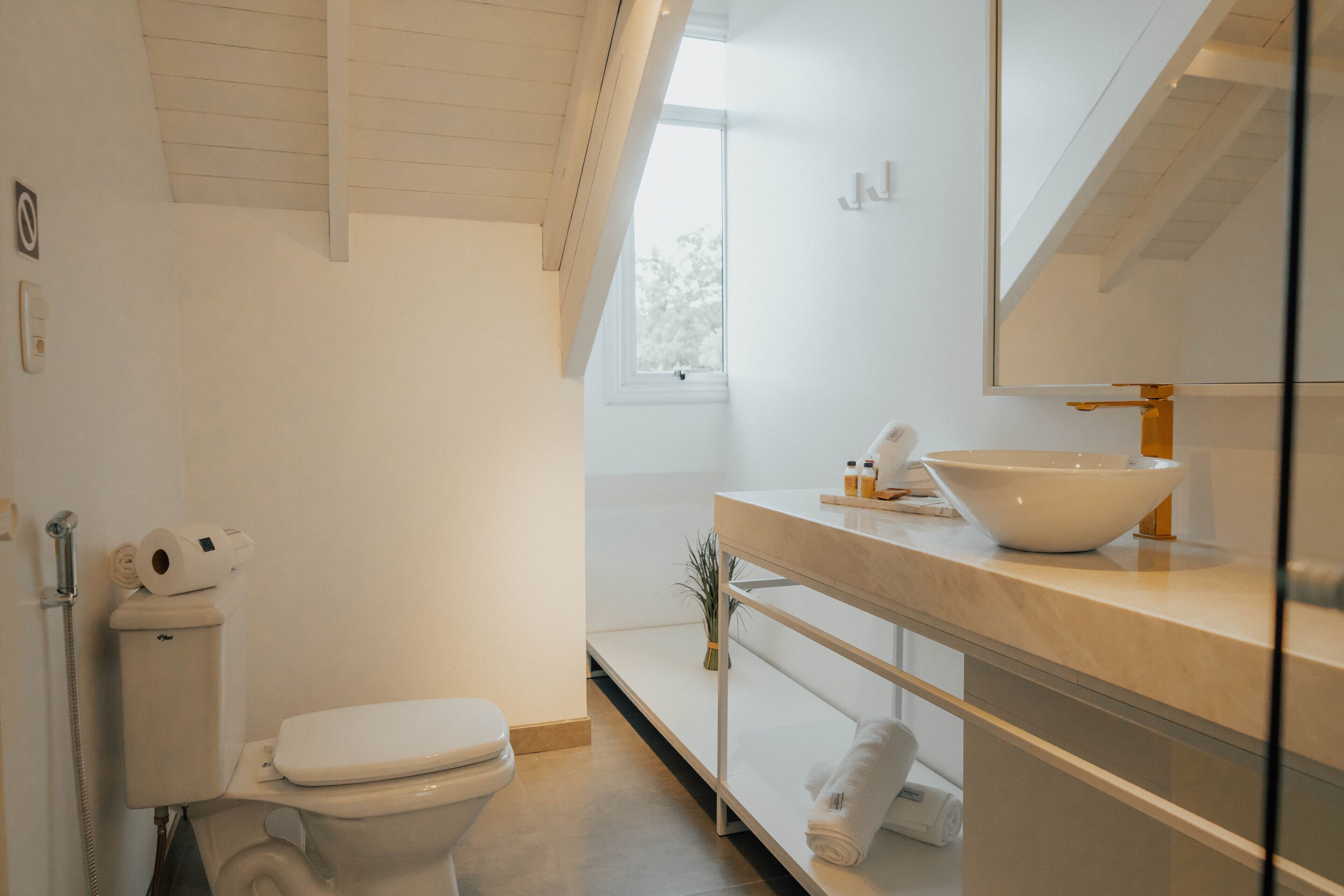 A modern bathroom with a toilet, sink, and mirror.