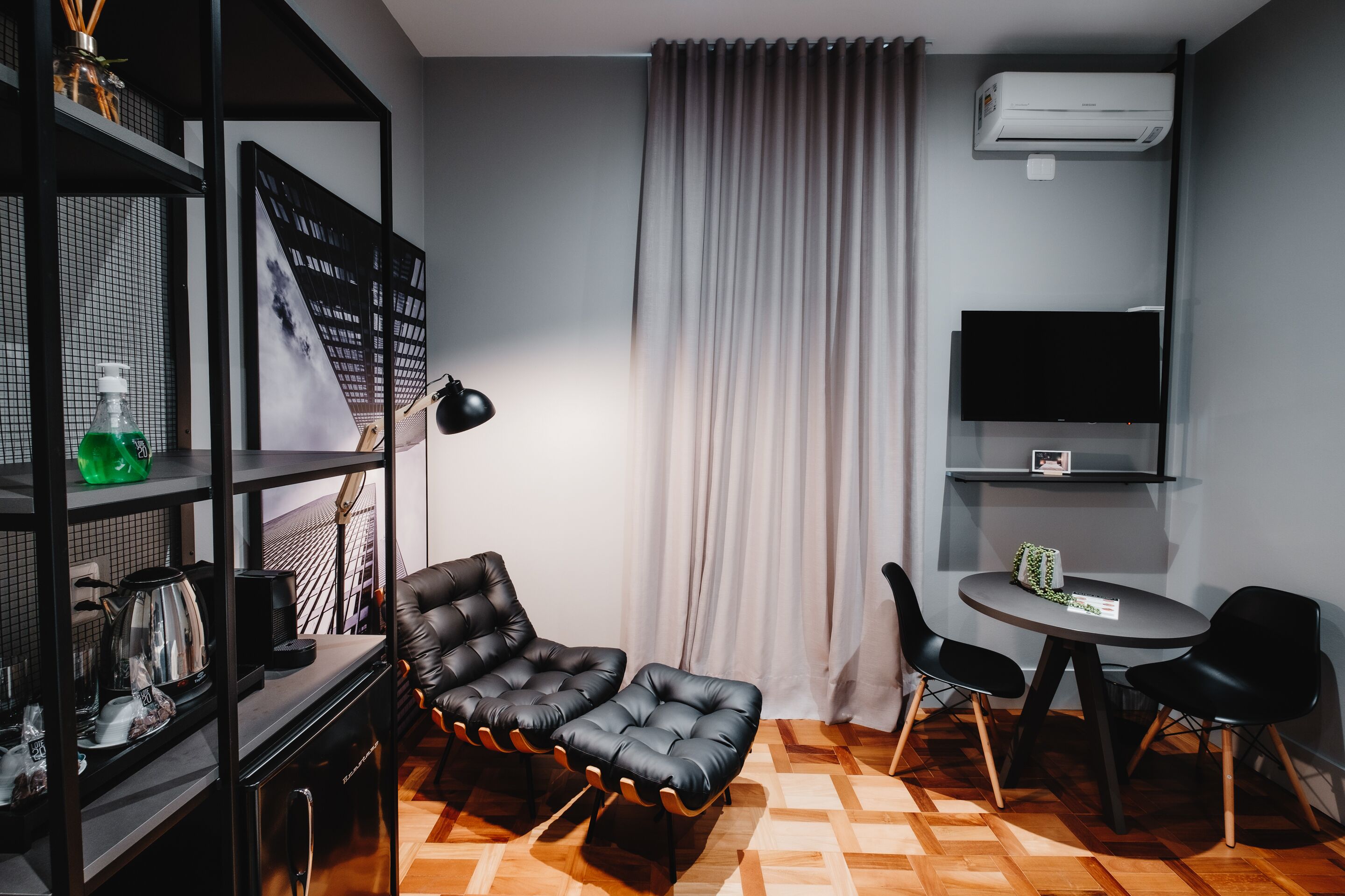 Un salon moderne avec un canapé, des fauteuils, un téléviseur et une table basse.