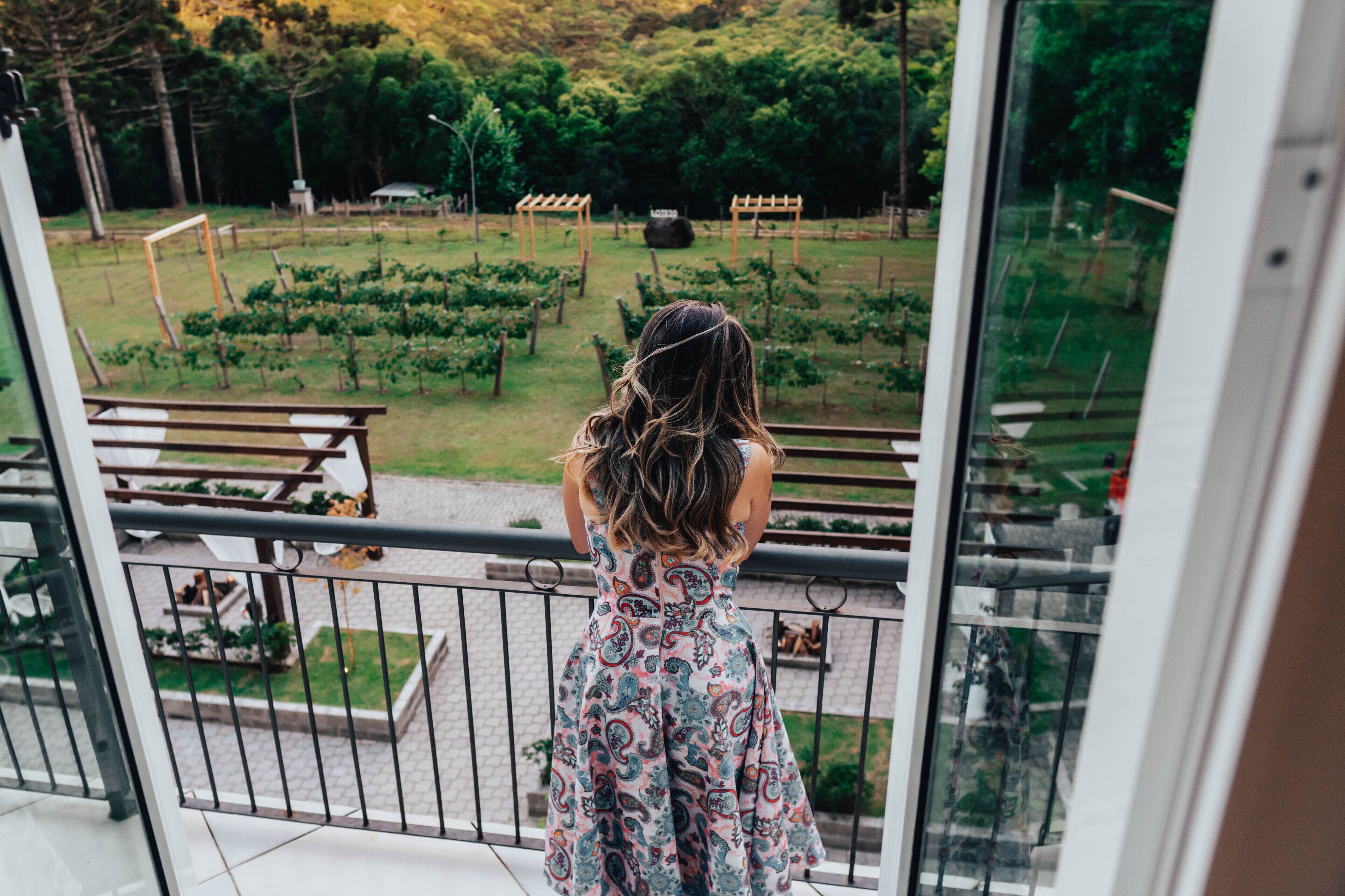 A balcony with a view of a vineyard and a pergola.