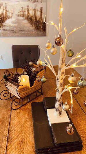 A Christmas tree with ornaments and candles on a wooden table.