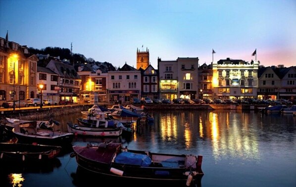 A waterfront town with buildings, a tower, and boats docked.