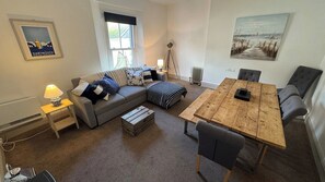 A cozy living area with a sofa, a coffee table, and a dining table.