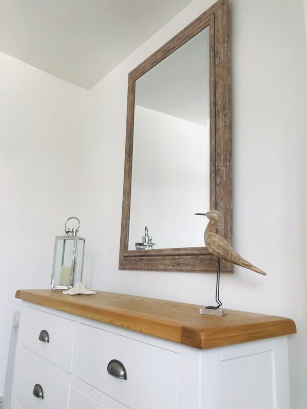 A bathroom vanity with a wooden countertop, a mirror with a rustic frame, and a decorative bird. - Dartmouth Town Center Stylish Apt Nancie & Parking (Dartmouth)