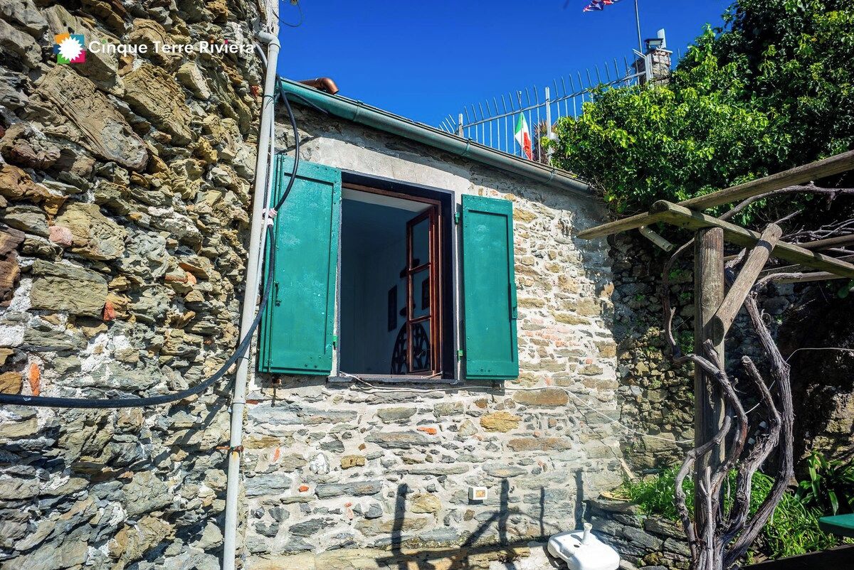 Un bâtiment en pierre avec une fenêtre et une clôture en métal.