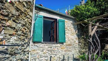 Un bâtiment en pierre avec une fenêtre et une clôture en métal.