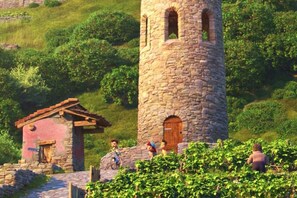 A stone tower, a small red-roofed building, and a pathway.