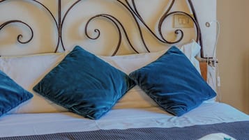 Un lit avec une tête de lit en métal, deux oreillers et une couverture.