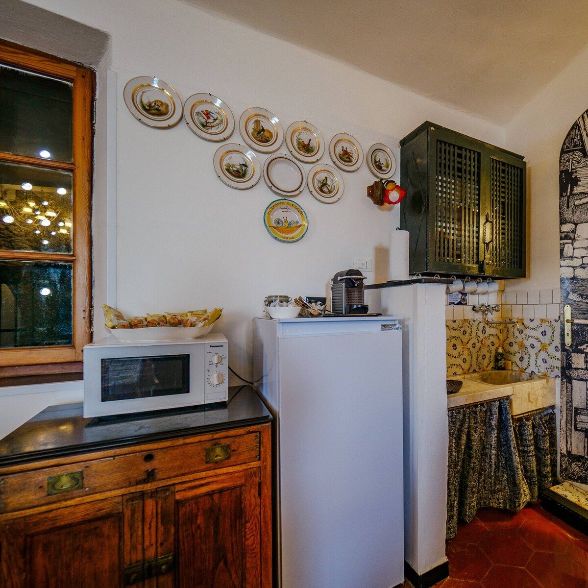 Una cocina compacta con microondas, refrigerador y un armario.