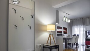 Una sala de estar moderna con comedor, que incluye una lámpara, arte en la pared y una luminaria.