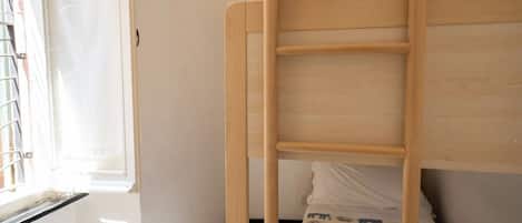 Un lit superposé avec une structure en bois et un matelas à motifs.