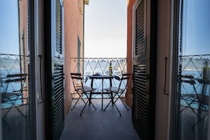 Balcón con mesa y sillas, con vista a un cuerpo de agua.