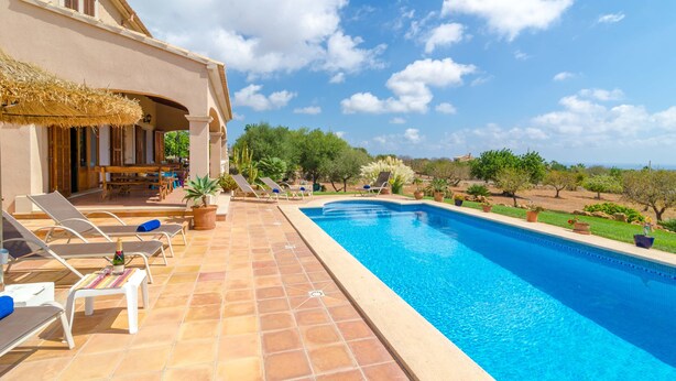 A swimming pool with lounge chairs and a patio area, surrounded by greenery and a clear sky. - CAN MARINES - Villa with private pool in Calonge - Santanyí. Free WiFi. (Calonge)