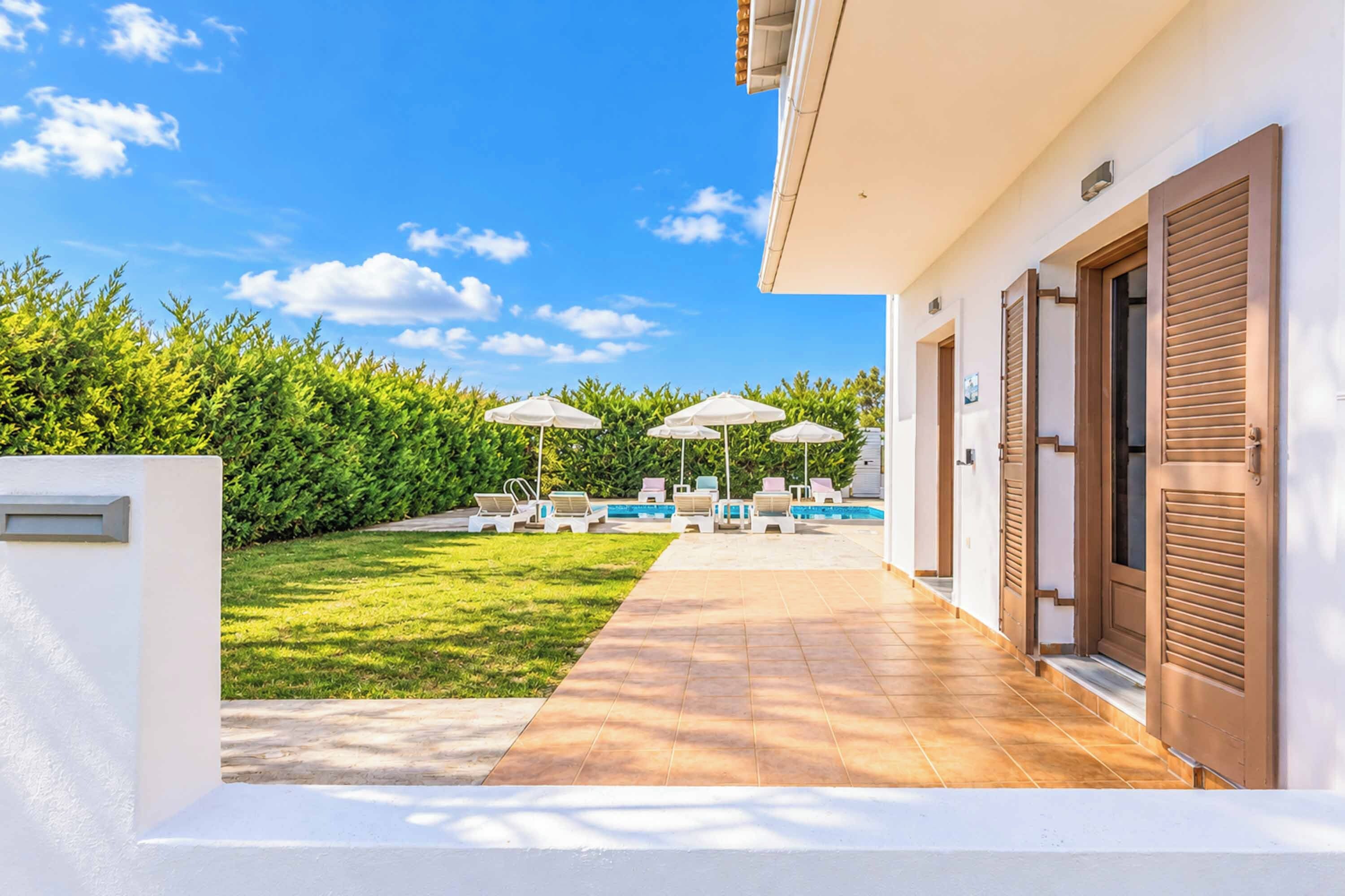 Eine moderne Villa mit Schwimmbad, Außenbereich und einem gepflegten Garten.
