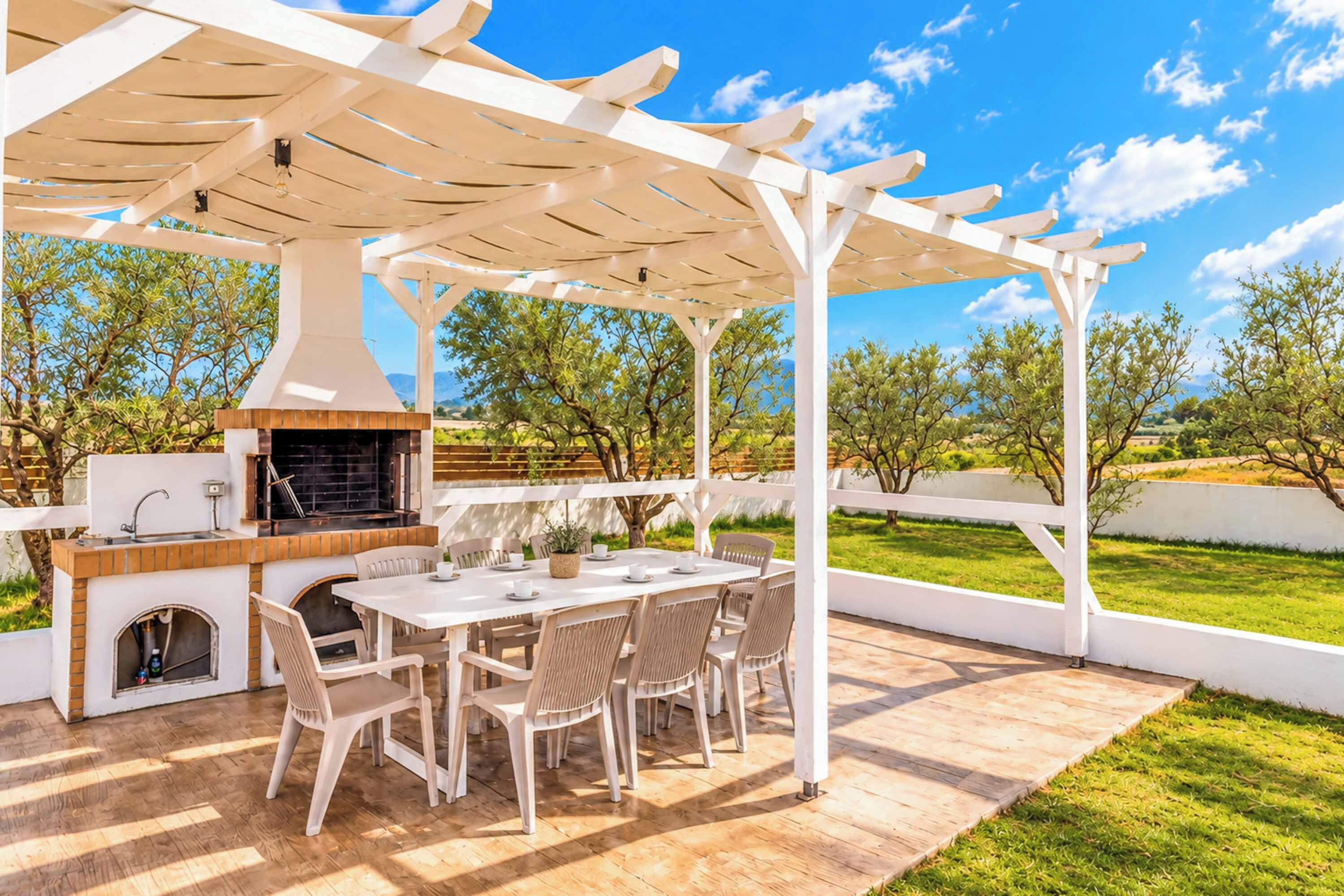 An outdoor patio with a grill, table, and chairs.