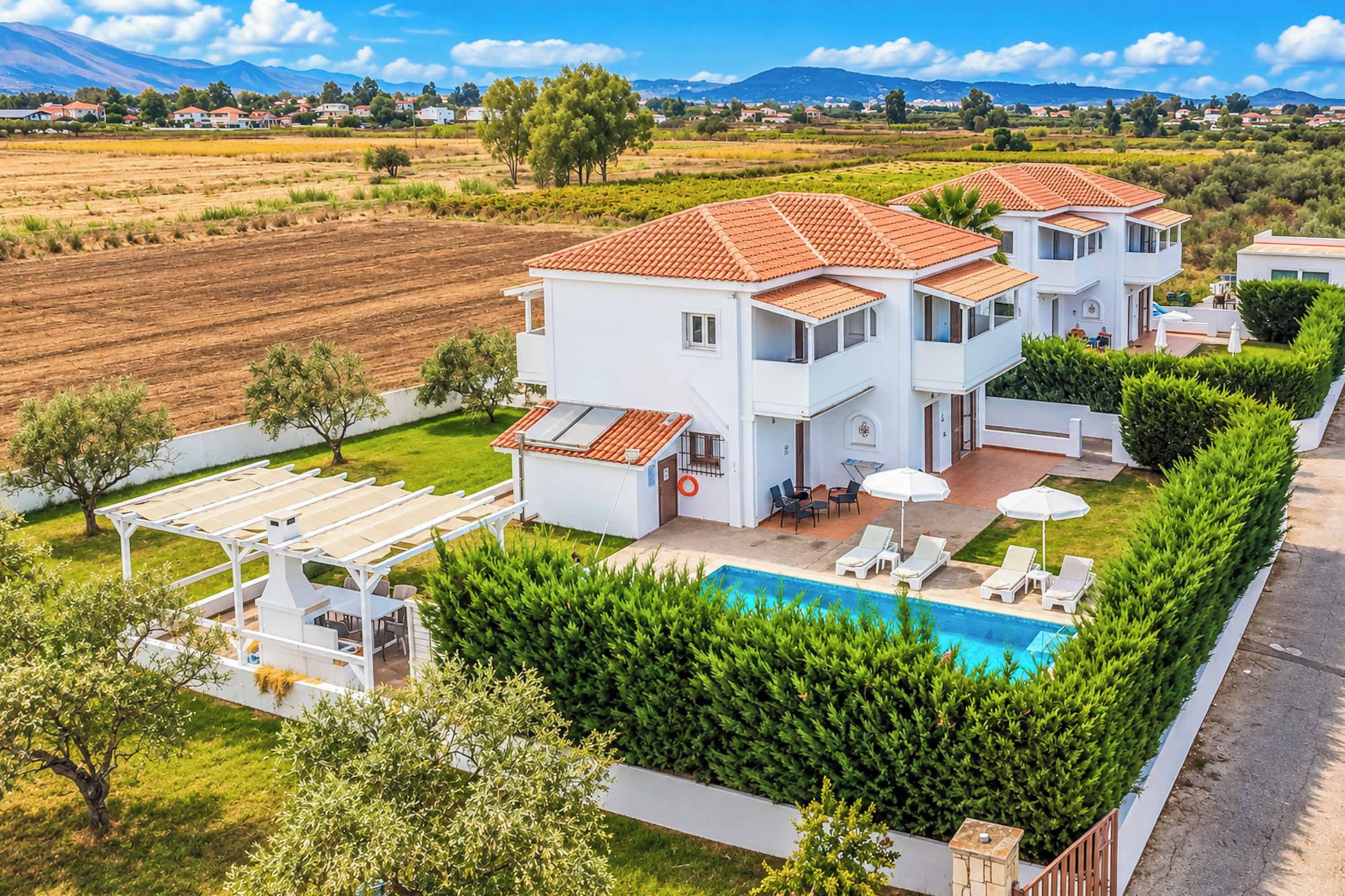 Ein zweistöckiges Haus mit Pool, Außenbereich und Blick auf die umliegende Landschaft.