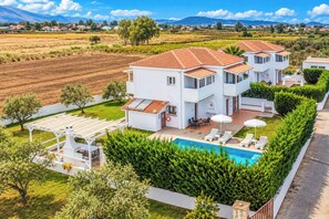 A two-story house with a swimming pool, outdoor seating, and a view of the surrounding landscape. - Villa Rodi - Four Bedroom Villa, Sleeps 9 (Zakynthos)