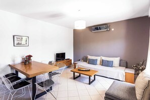 A modern living room with a sofa, a dining table, and chairs. - Villa Rodi - Four Bedroom Villa, Sleeps 9 (Zakynthos)